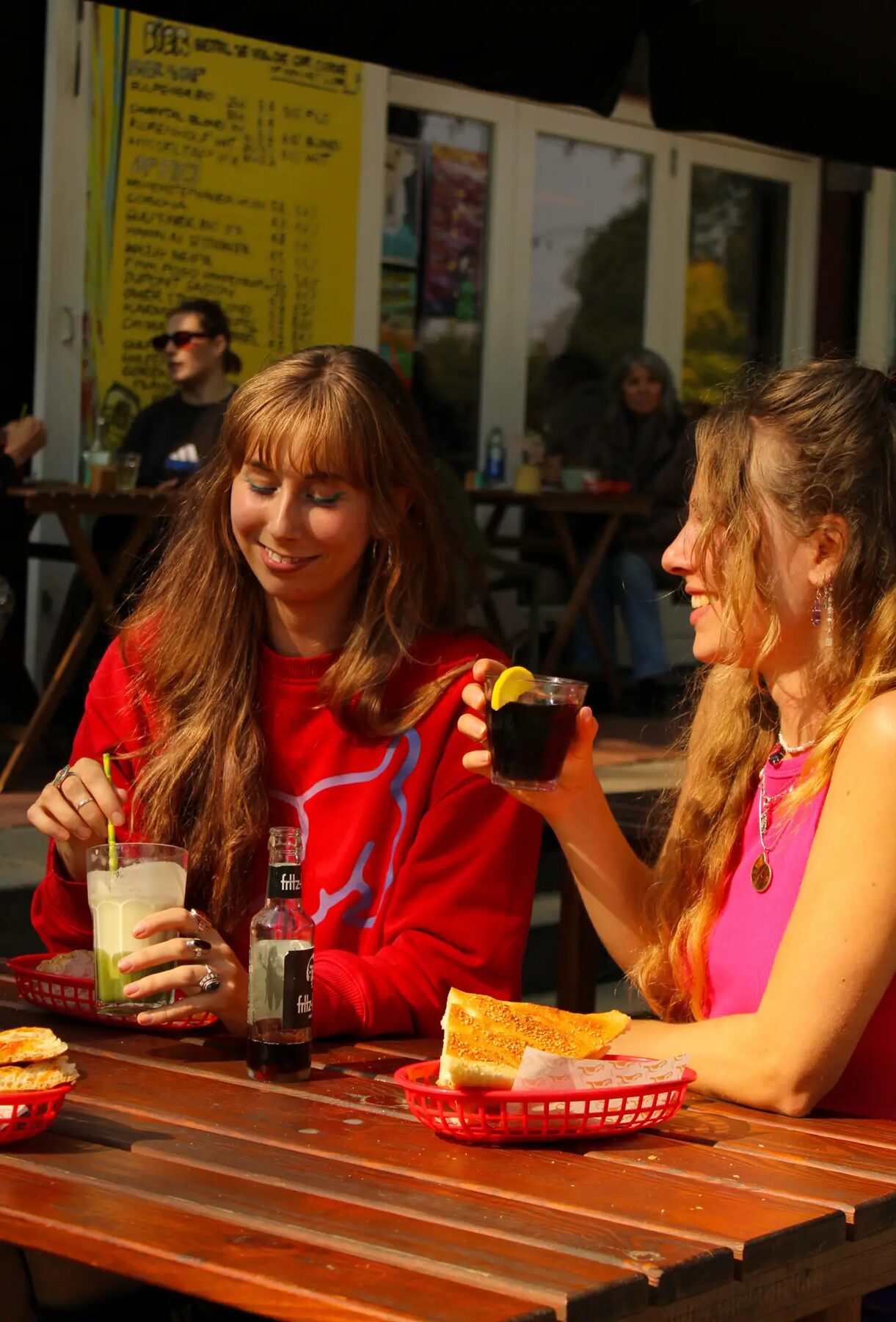 Twee vriendinnen proosten op het terras