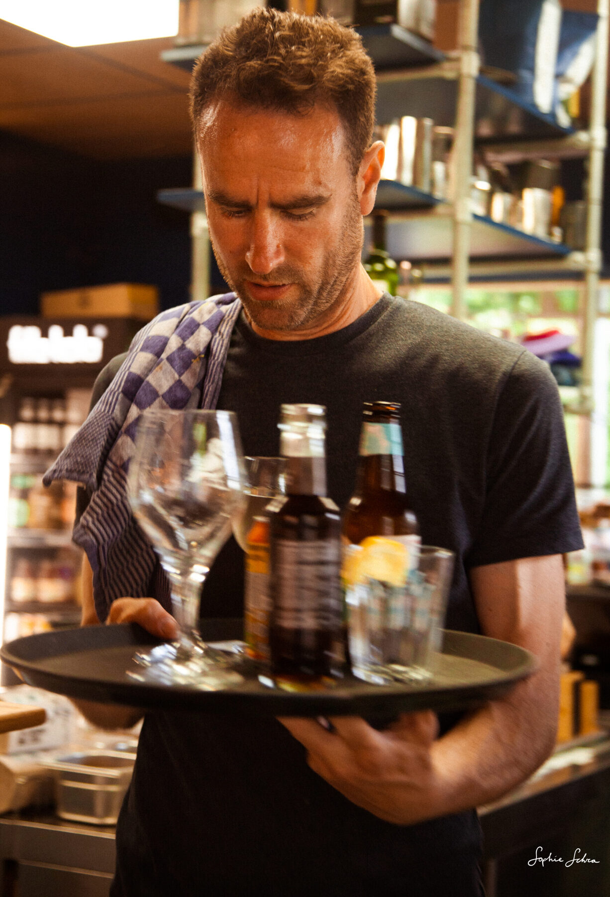 Een medewerker van Terrasmus met een dienblad vol drankjes