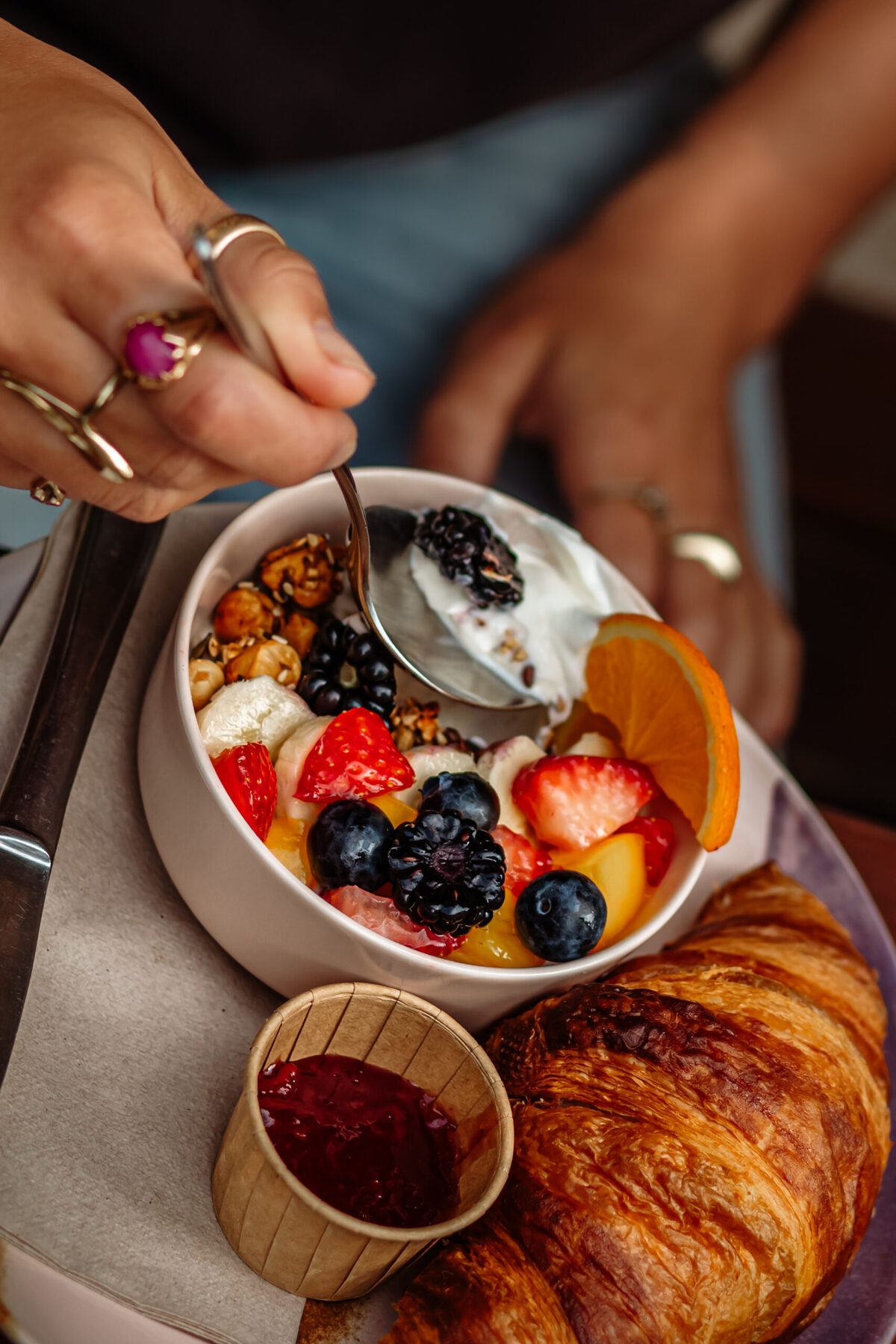 Yoghurt met granola en vers fruit, met een croissant